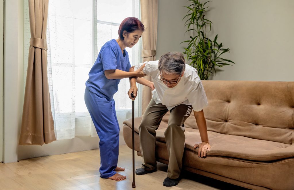 Doctora ayudando a adulto mayor a realizar ejercicios.